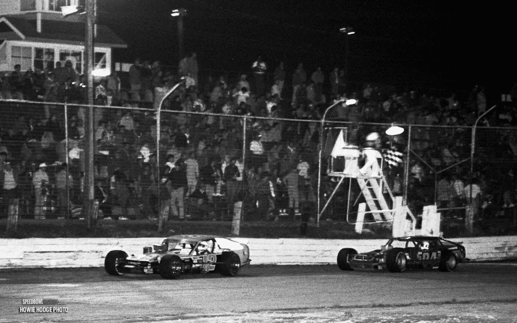 Black and white abstract pattern with concentric circles and wave shapes.