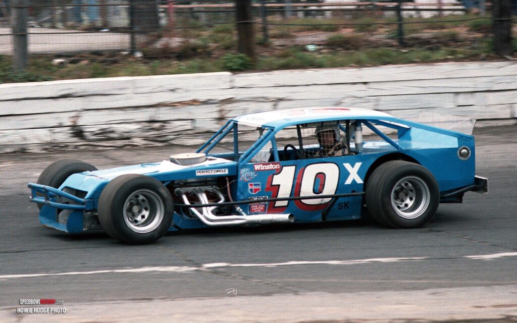 Black and white abstract pattern with concentric circles and wave shapes.