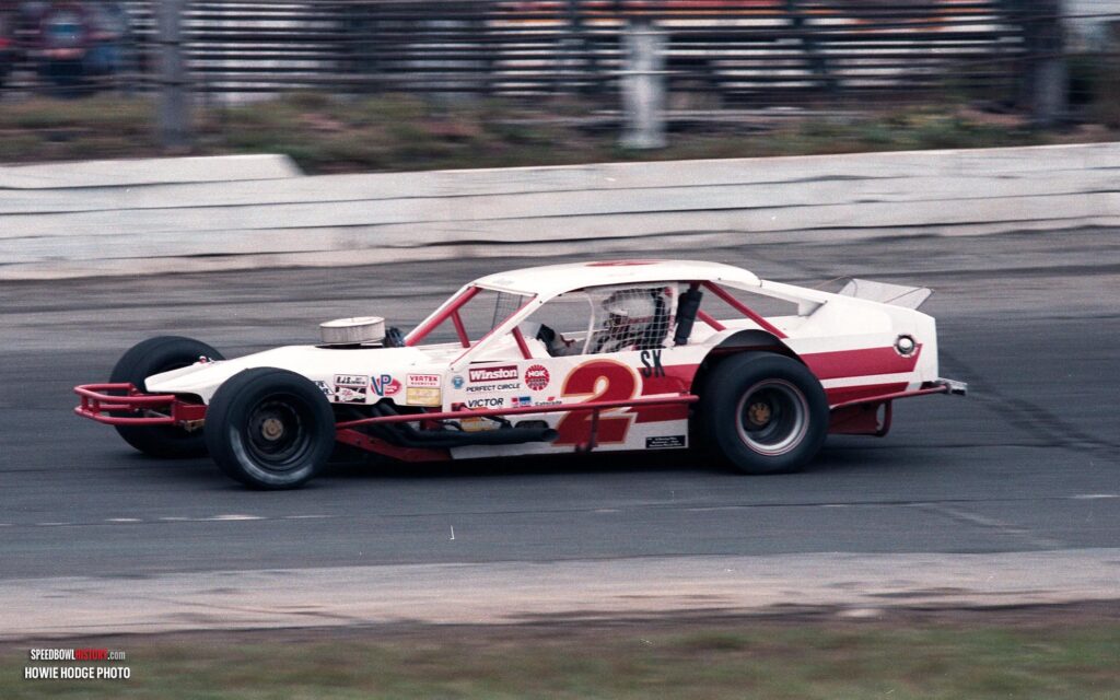 Black and white abstract pattern with concentric circles and wave shapes.