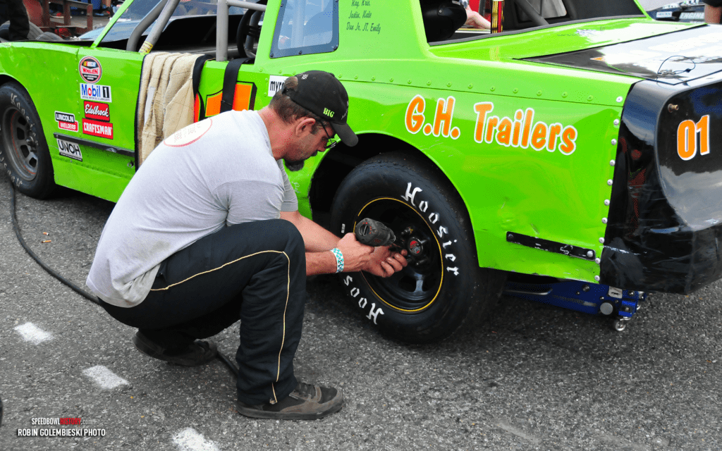 Mechanic changing a racing car's tire during an event.
